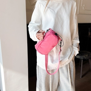 Pink nylon crossbody water bottle bag shown on a model for size reference