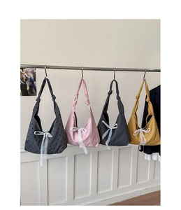 Detail of four colorful polka dot canvas tote bags with elegant white lace bows