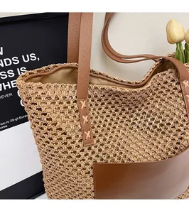 Detailed close-up of woven straw beach bag with brown leather handles and front pocket