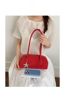 Chic red bowling handbag with silver star pendant worn by a model in white knitwear