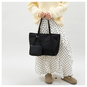 Détail du sac cabas minimaliste en nylon noir avec pochette sur mannequin femme