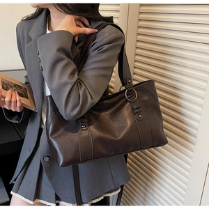 Detail of soft dark brown leather tote bag with silver hardware and vertical stitching