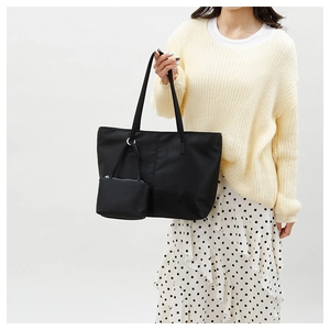 Détail du grand sac cabas en nylon noir avec pochette amovible porté par un mannequin