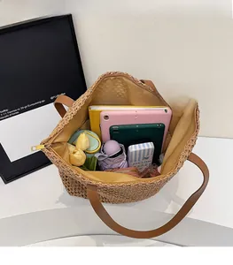 Top view showing the spacious interior of straw tote bag with brown leather handles