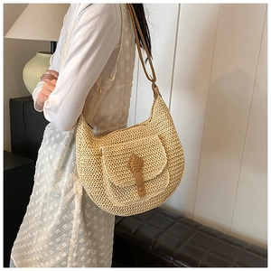 Close-up of the large woven hobo bag with a brown leather strap and vintage buckle detail