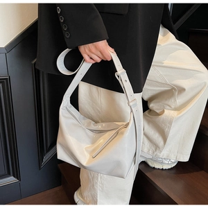 Minimalist creamy white hobo bag with adjustable wide strap and soft glossy texture