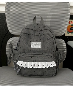 Close-up of dark grey corduroy backpack with cute bear print and lace trim details