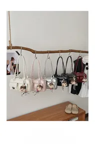 Collection of retro shoulder bags in multiple colors hanging on a creative wood display