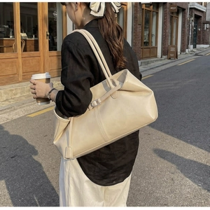 Détail latéral du sac cabas beige crème en cuir avec décoration de sangle à boucle chic