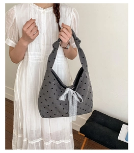 Detail of grey polka dot canvas tote bag with lace bow and knotted shoulder strap