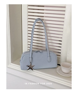 Detail of light blue minimalist rectangular handbag with silver star charm and thin straps