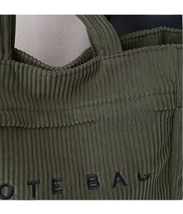 Gros plan sur le sac fourre-tout en velours côtelé vert foncé avec détails de broderie