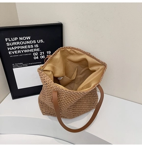 Detail view of the spacious straw tote bag interior with fabric lining and leather straps