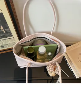 Interno spazioso di una borsa tote rosa con laptop e prodotti di bellezza essenziali