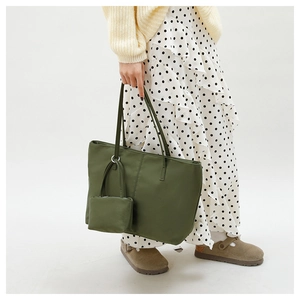 Détail d'un sac cabas en nylon vert armée avec pochette zippée et longues anses