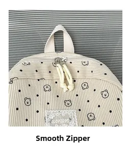Detail of corduroy backpack with cute bear print, smooth dual zippers and logo patch