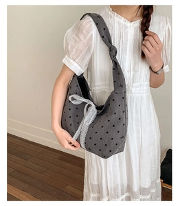 Detail of grey canvas tote bag with black polka dots and white lace bow decoration