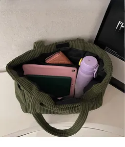 Vue détaillée de l'intérieur du sac cabas en velours côtelé vert avec multiples poches