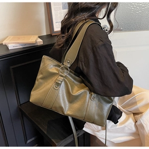Detailed view of an olive green vintage leather tote bag with stylish metal ring hardware