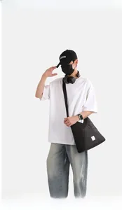Dettaglio della borsa tote in nylon nero con cuciture geometriche e logo del marchio