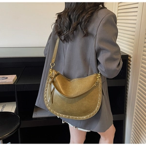 Detail of olive green hobo bag featuring golden rivets and versatile leather shoulder strap