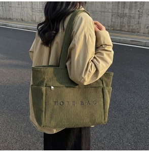 Détail du sac fourre-tout en velours côtelé vert foncé avec broderie et poches