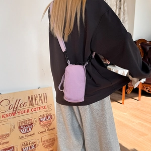 Detail view of lightweight light purple nylon crossbody bag showing the side strap handle