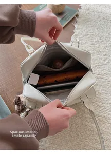 Macro shot showing the spacious interior of a cream leather tote bag with various items