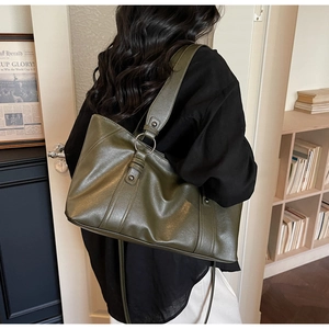 Detail of olive green PU leather tote bag with metallic ring and reinforced stitching
