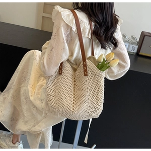 Detail of bohemian woven tote bag with brown leather straps and sturdy cross-stitch craft