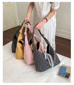 Detail view of large canvas tote bags with polka dots and knotted shoulder straps