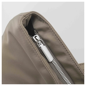 Détail de la fermeture éclair en métal argenté et du tissu en nylon kaki du grand sac