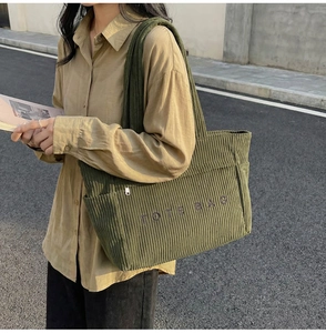 Gros plan sur le sac fourre-tout en velours côtelé vert foncé avec broderie élégante