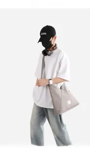 Borsa a tracolla in nylon grigio con design a triangolo asimmetrico ed etichetta tessuta