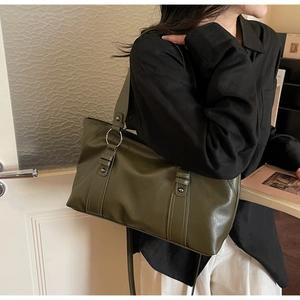 Detail of olive green soft leather tote bag with silver ring and long shoulder strap