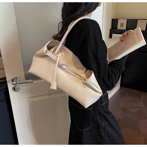 Détail du sac cabas beige minimaliste avec texture cuir et boucle métallique élégante