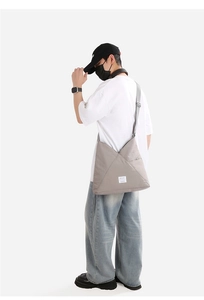 Borsa a tracolla in nylon grigio chiaro con design geometrico indossata da modella