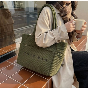 Photo de mode d'un sac cabas en velours côtelé vert armée avec broderie de lettres