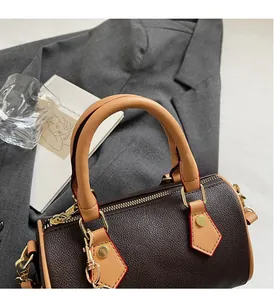 Close-up of pebble leather boston bag with contrast handles and red edge paint detail