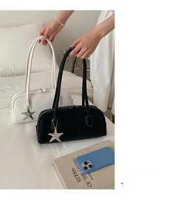 Minimalist leather bowling handbag featuring a silver starfish charm in black and white