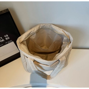 Top view showing the spacious interior and inner pocket of the cream nylon tote bag