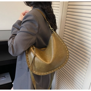Side view of olive green leather hobo bag featuring gold studs and long leather zipper puller