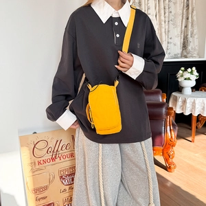 Ginger yellow nylon crossbody mobile phone bag with adjustable strap worn by model