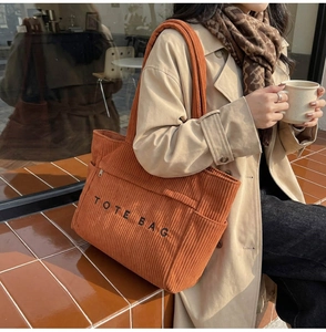 Détail du sac fourre-tout en velours côtelé caramel avec poche latérale et lettrage imprimé