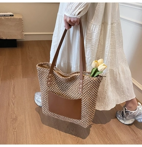 Detail of hand-woven straw tote bag with leather pocket and shoulder straps for beach