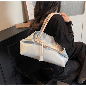 Sac fourre-tout bleu clair chic porté par un mannequin dans un décor minimaliste
