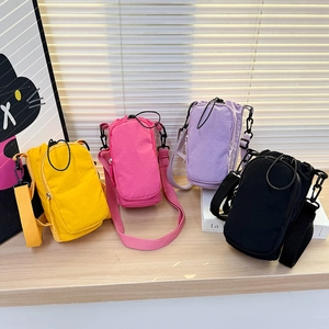 Detail view of four colorful lightweight mini crossbody bags on a wooden surface