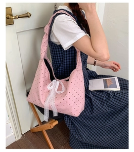 Pink polka dot canvas tote bag featuring a white lace bow detail on shoulder strap