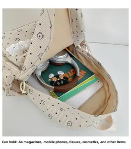 Detail view of the spacious corduroy backpack interior with bear print and daily items