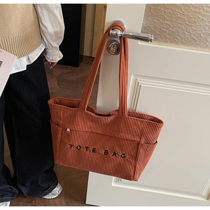 Vue détaillée du sac cabas en velours côtelé avec poche latérale zippée et broderie